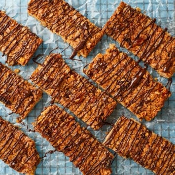 Golden brown Homemade Granola Bars are drizzled with chocolate.