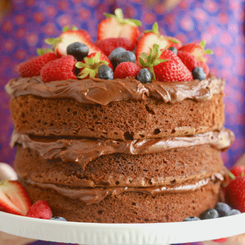 A 3-layer Chocolate Cake with frosting and fresh berries.