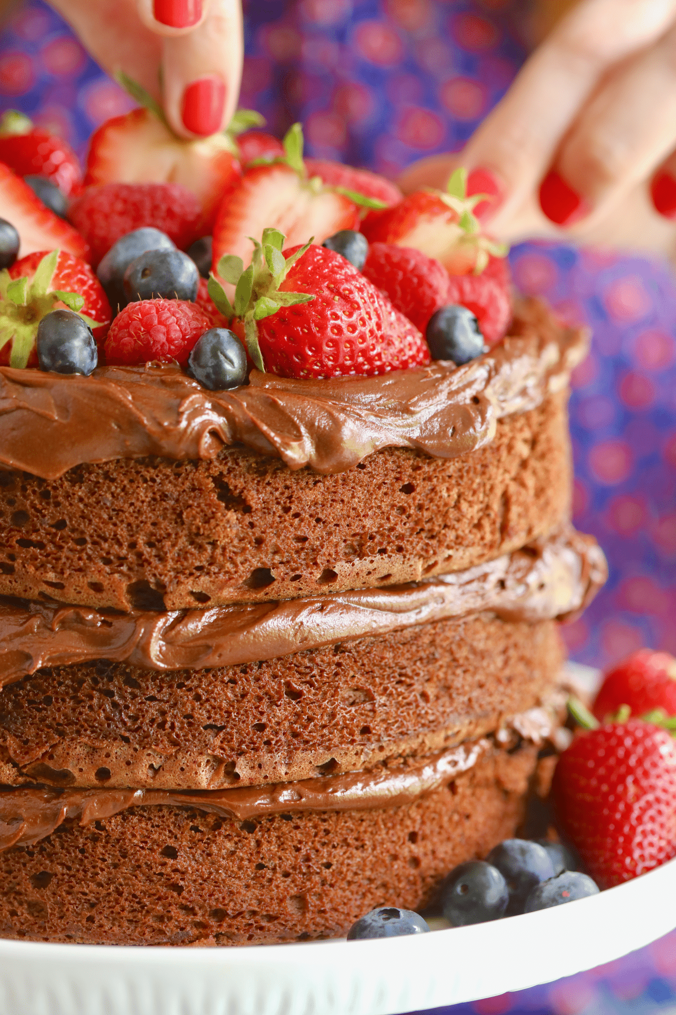 Microwave Chocolate Cake is frosted with chocolate frosting between layers and topped with fresh berries. 