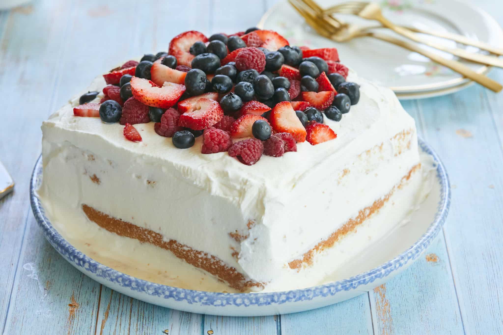 A tres leches cake piled with fresh berries.