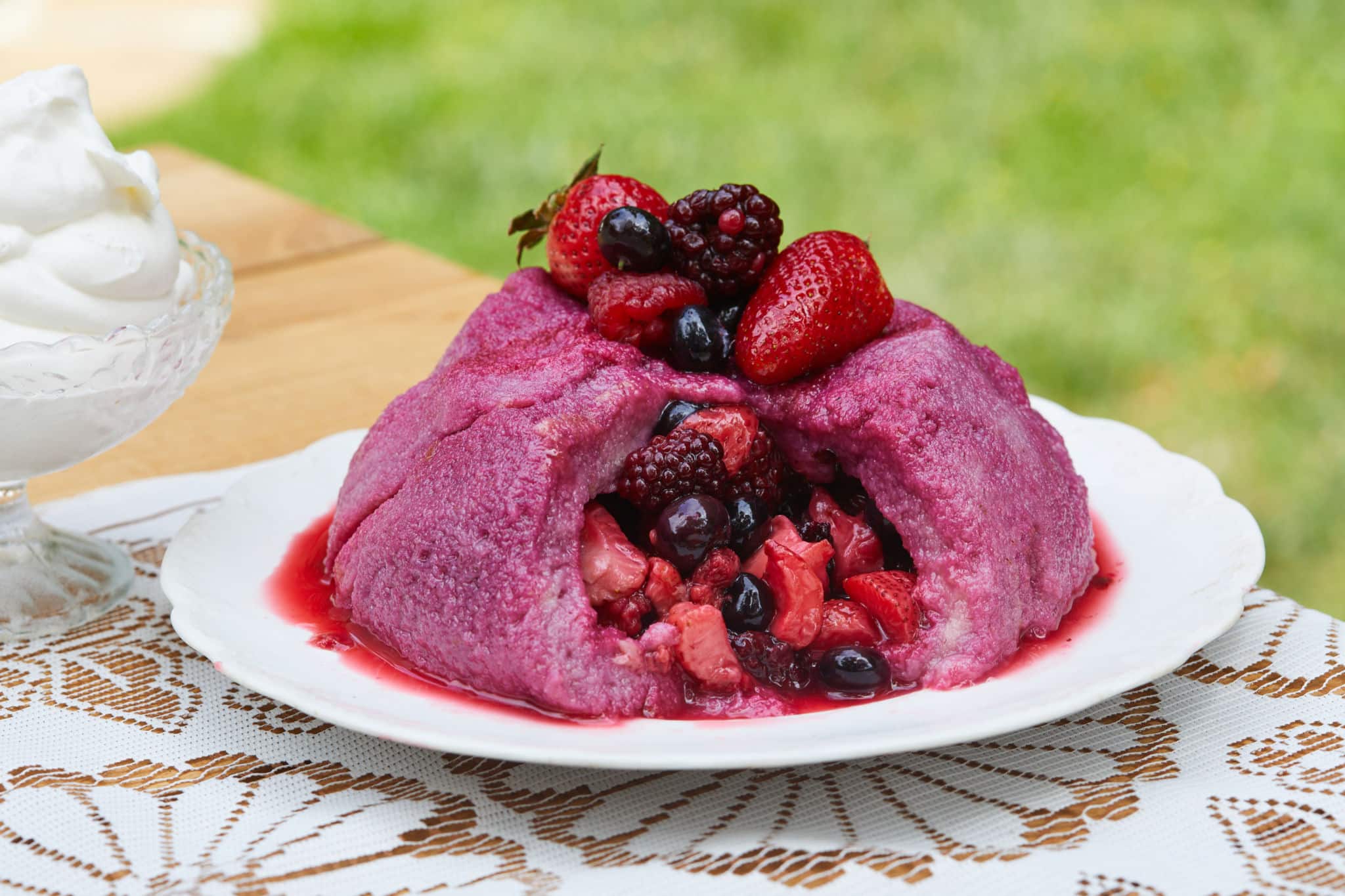 A summing berry pudding cake topped with fresh berries.