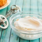 A would of stabilized whipped cream frosting next to a mixer.