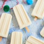 Piña colada popsicles laying flat on a table.