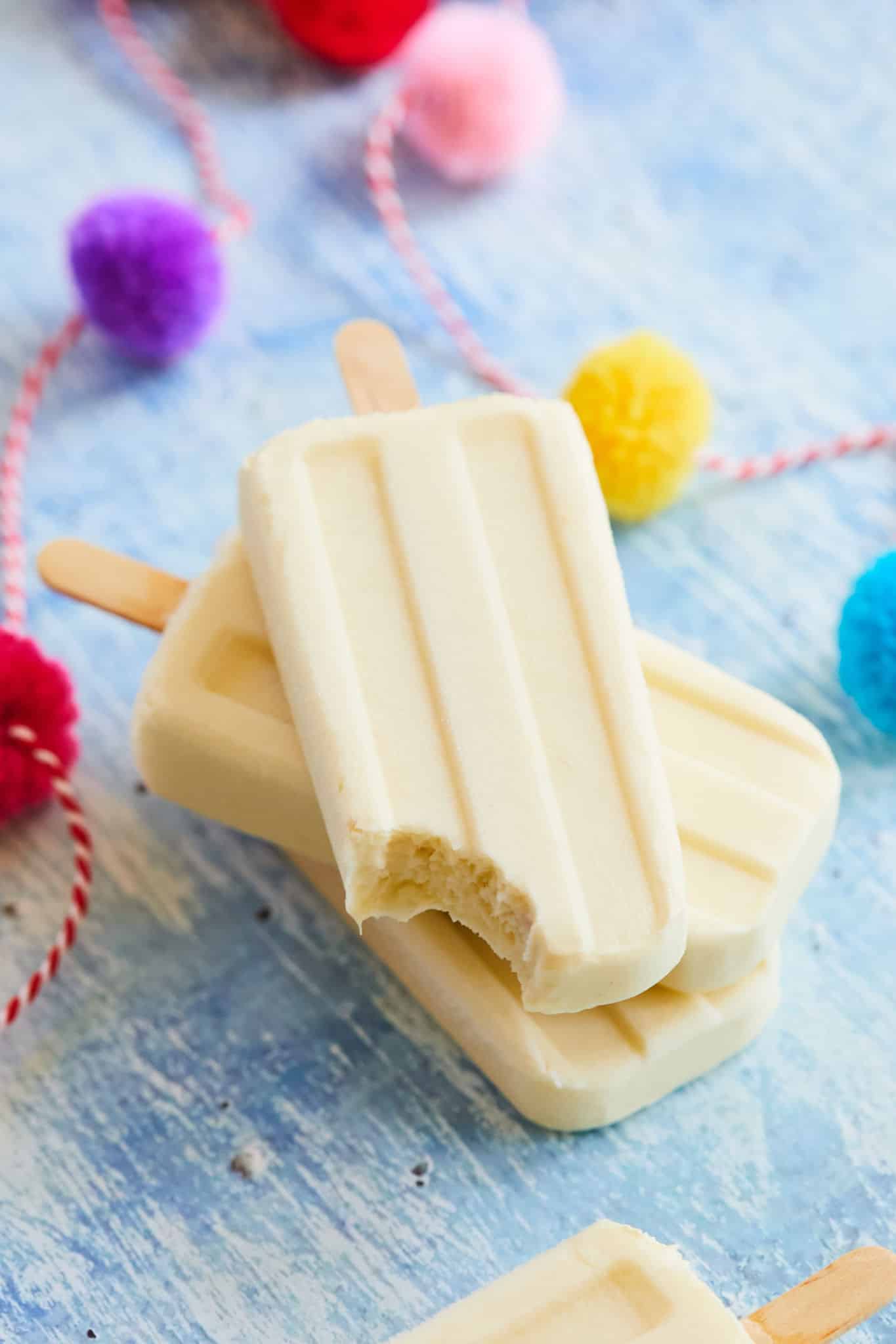 A piña colada popsicle from my recipe with a bite taken out of it.