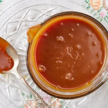 A jug of salted caramel with a spoonful next to it.