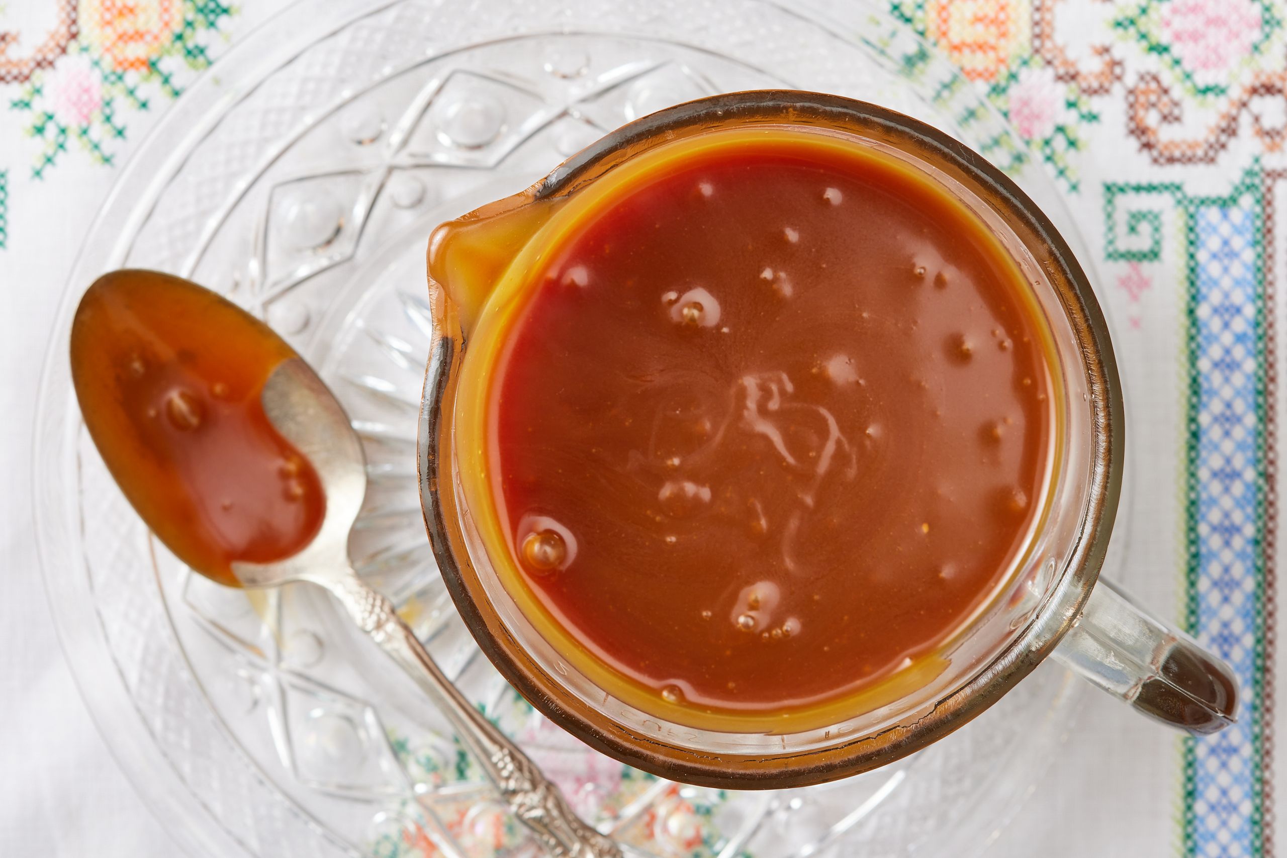 A jug of salted caramel with a spoonful next to it.