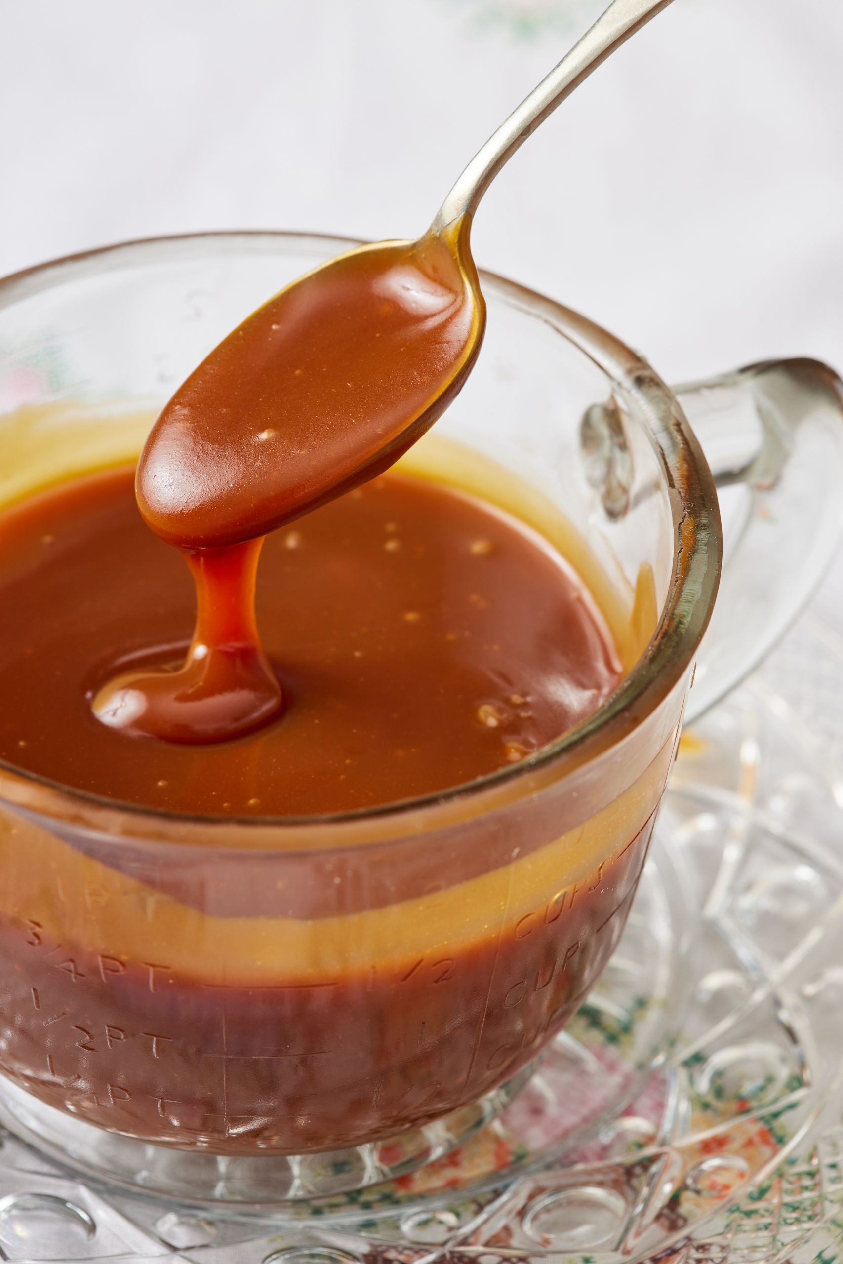 Smooth salad caramel dipping from a spoon into the jug. 