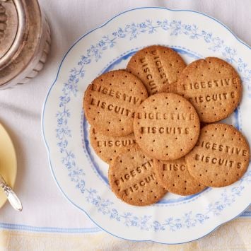 A top-down view of round, golden digestive biscuits served with tea.