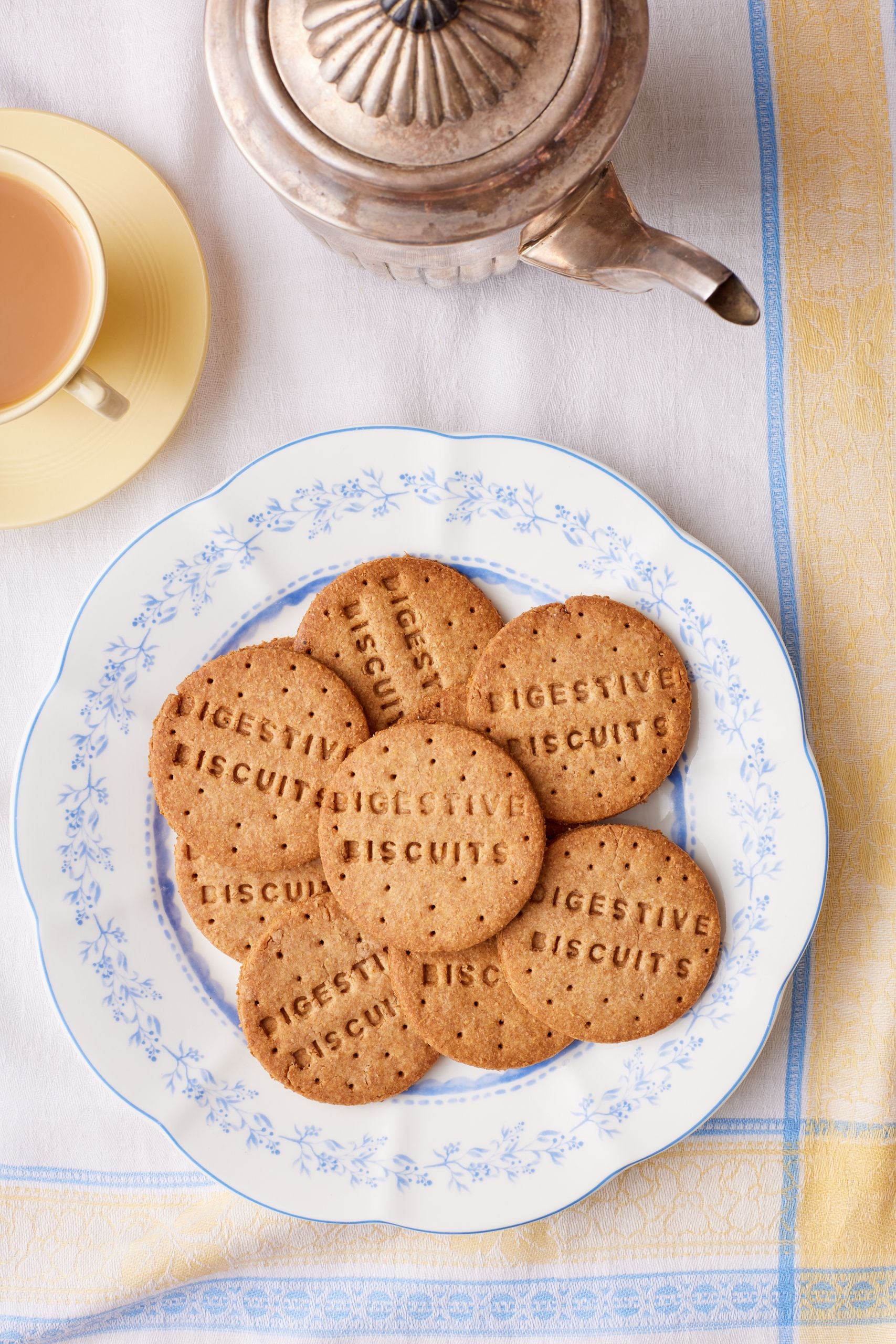 A top-down view of a plate of gold digestive biscuits.