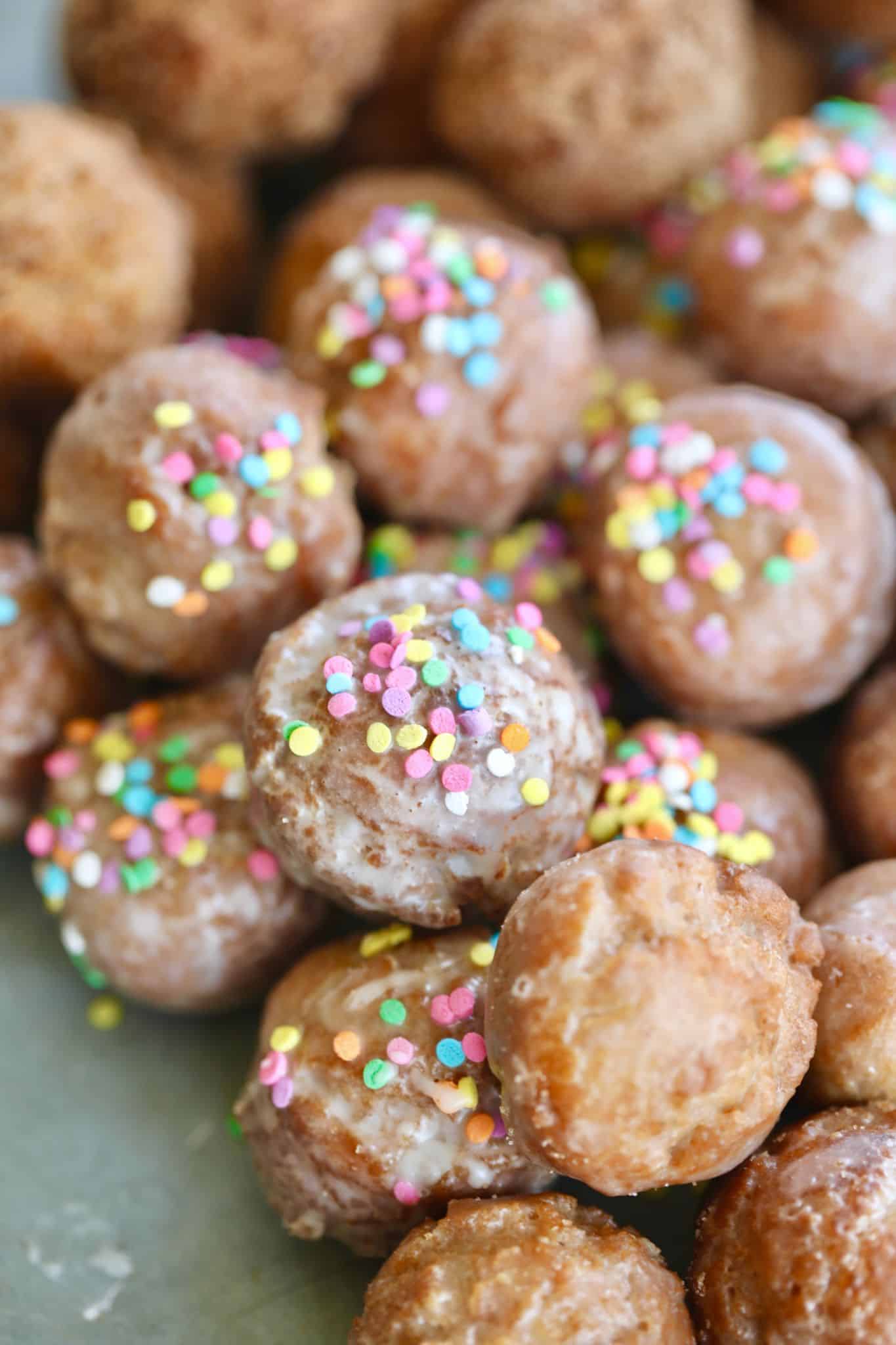 A close up of donut holes with sprinkles.