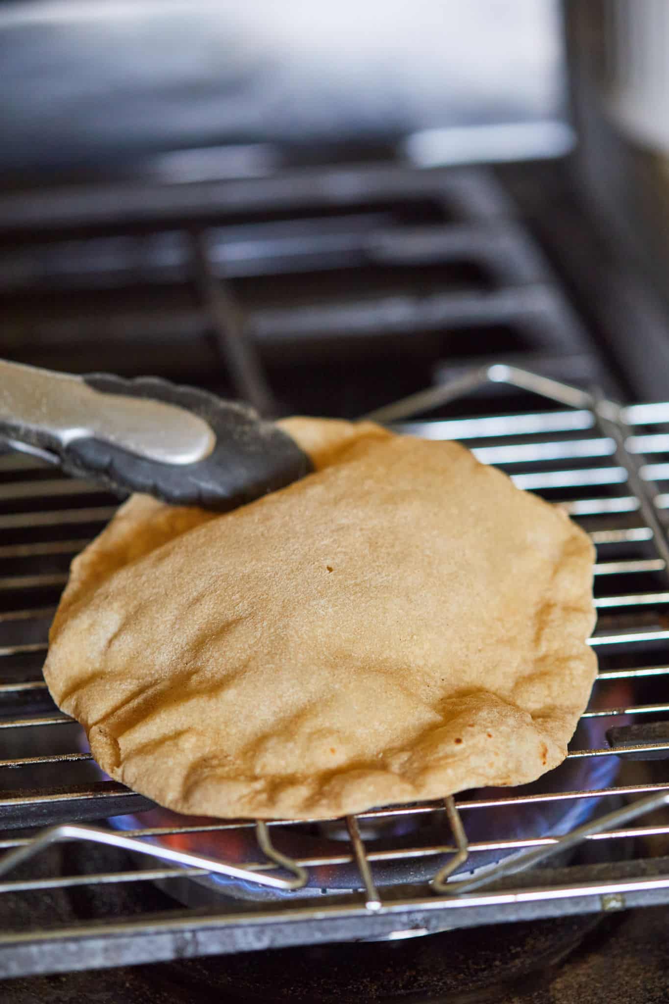 Roti being cooked over an open flame.