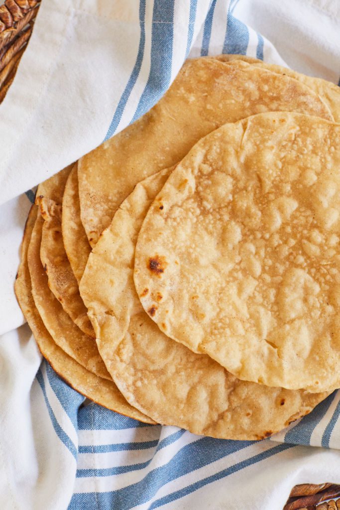 A basket of golden, soft, bubbly Indian roti.
