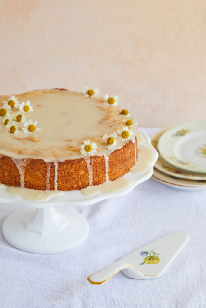 Sicilian Whole Orange Cake is covered with glaze and topped with flowers