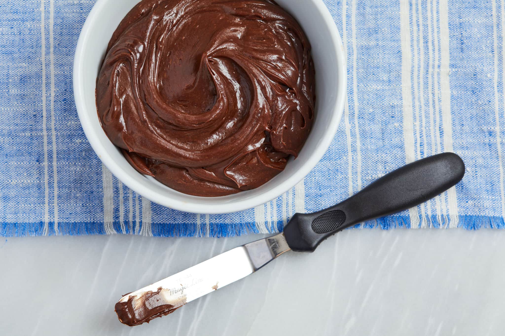 A bowl of chocolate buttercream frosting.