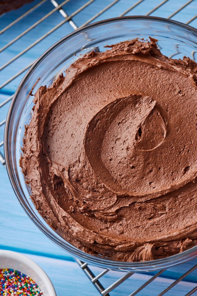 Top-down view of a bowl of smooth chocolate buttercream frosting.