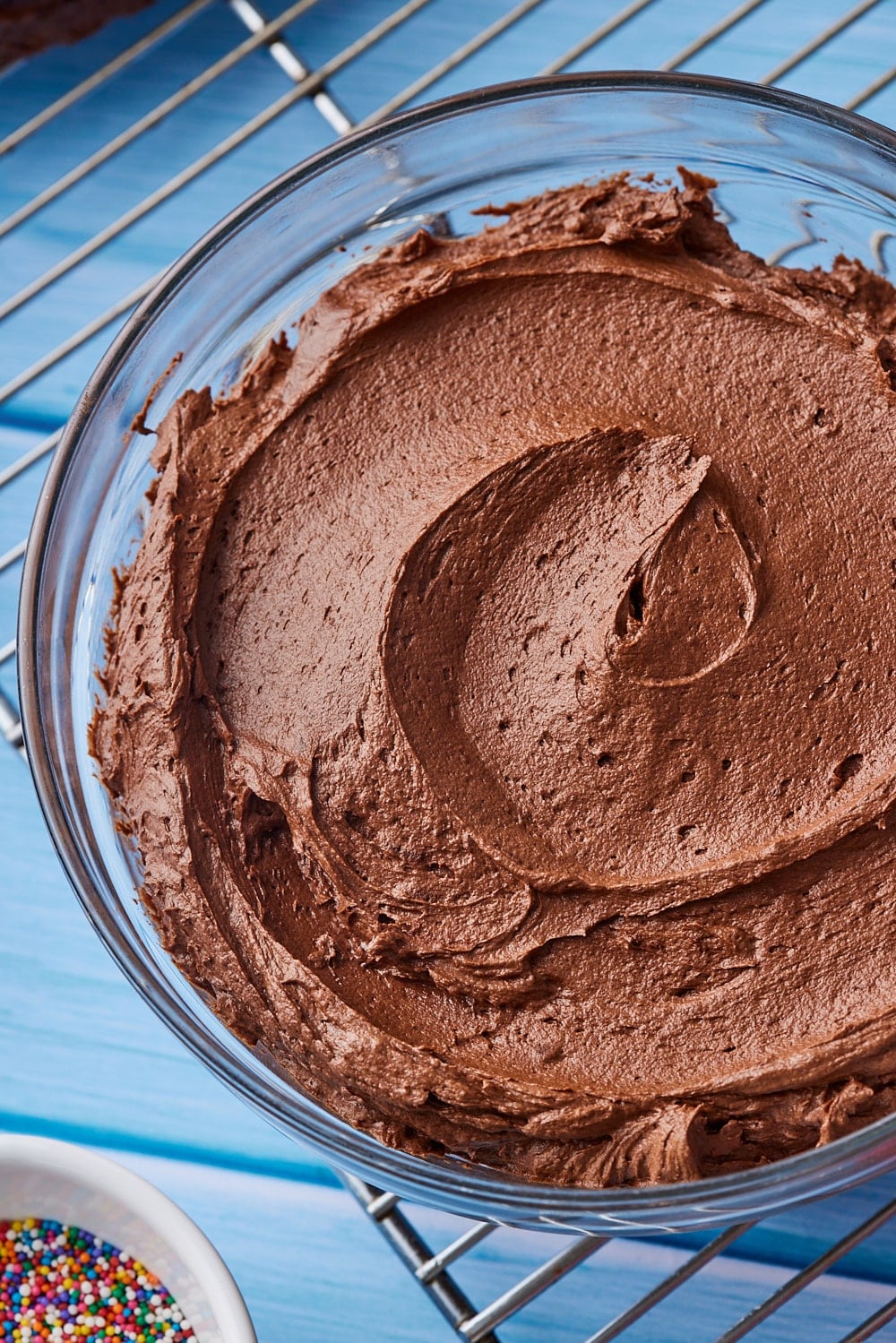 Top-down view of a bowl of smooth chocolate buttercream frosting. 