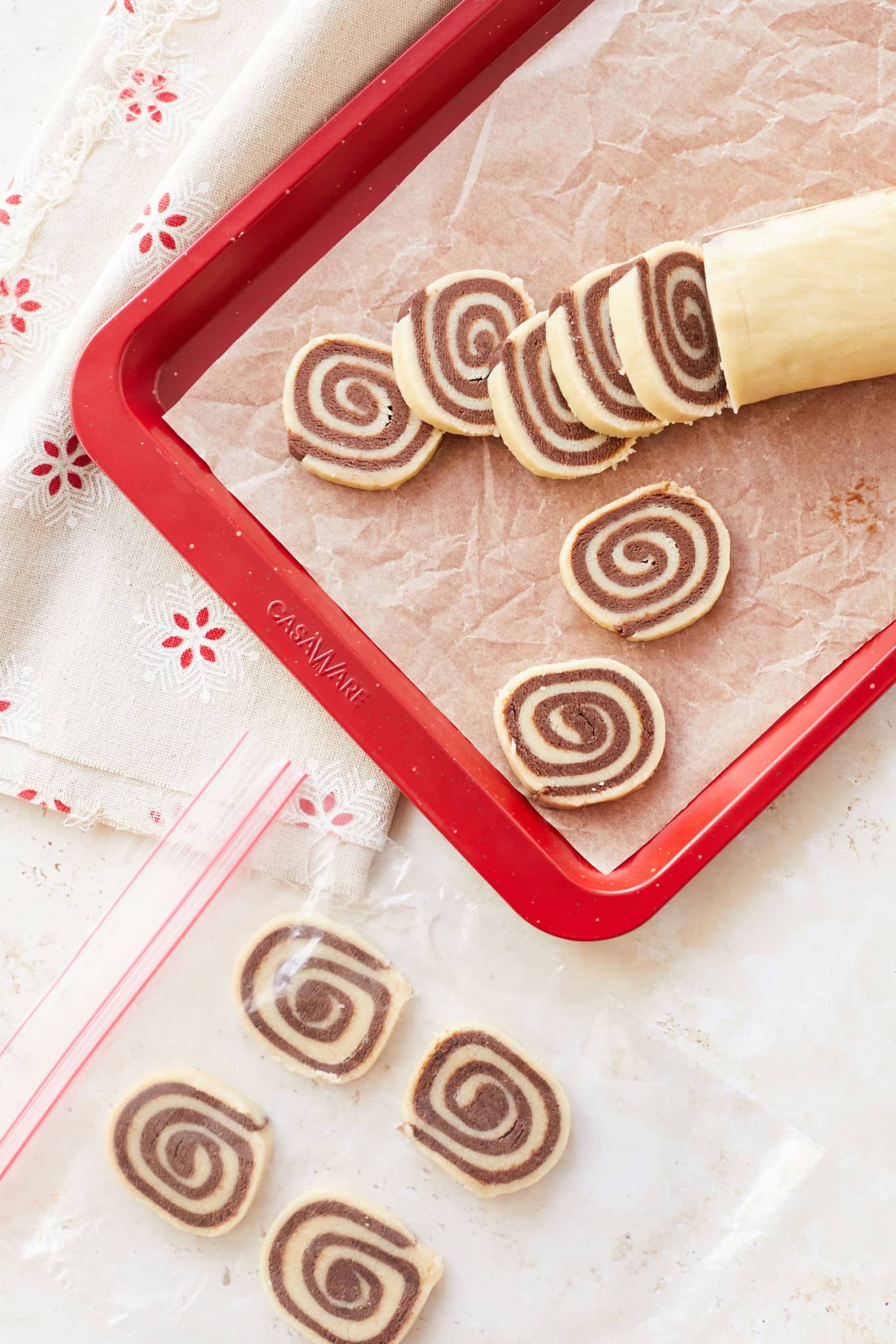 Sliced cookies on a baking tray and in a bag.