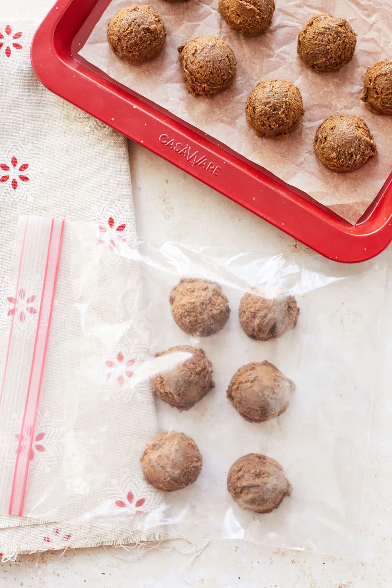 Cookie balls frozen on a tray and in a bag.