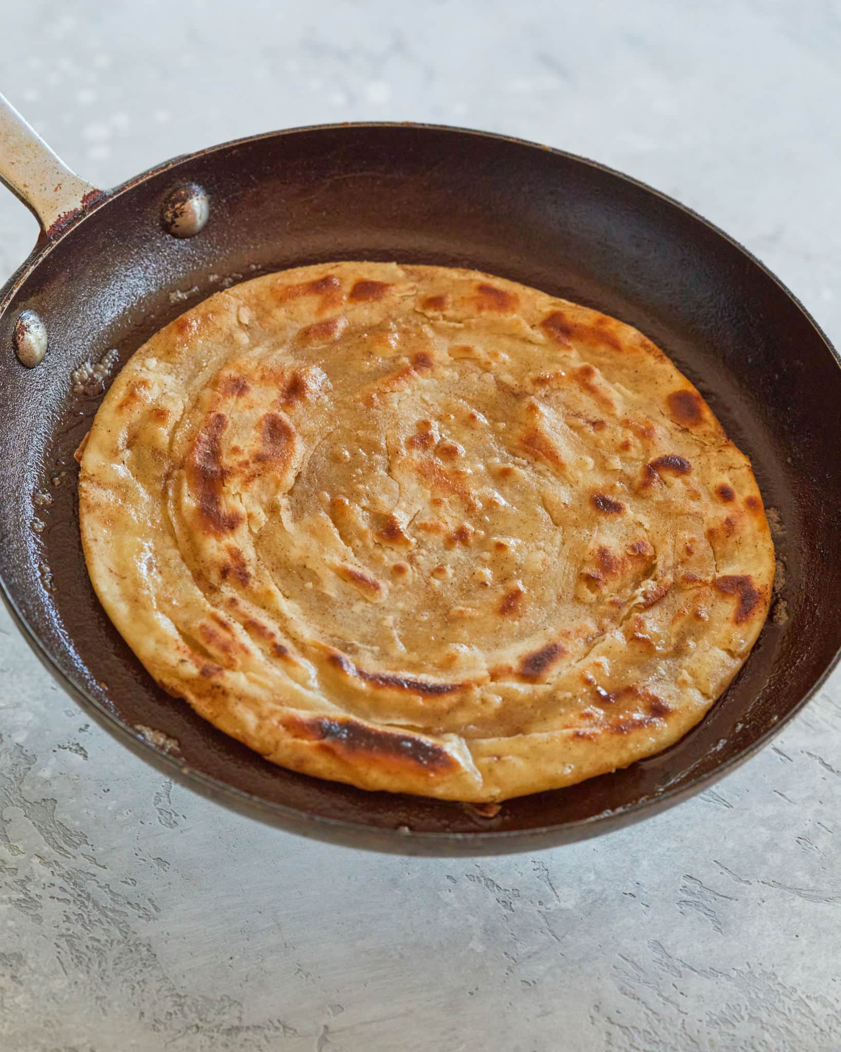 Paratha, finished, in a frying pan.