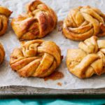 Swedish Cardamom Buns resting on a baking sheet.