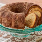 An apple cider donut cake covered in cinnamon sugar.
