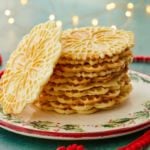 Homemade Pizzelle stacked on a plate.