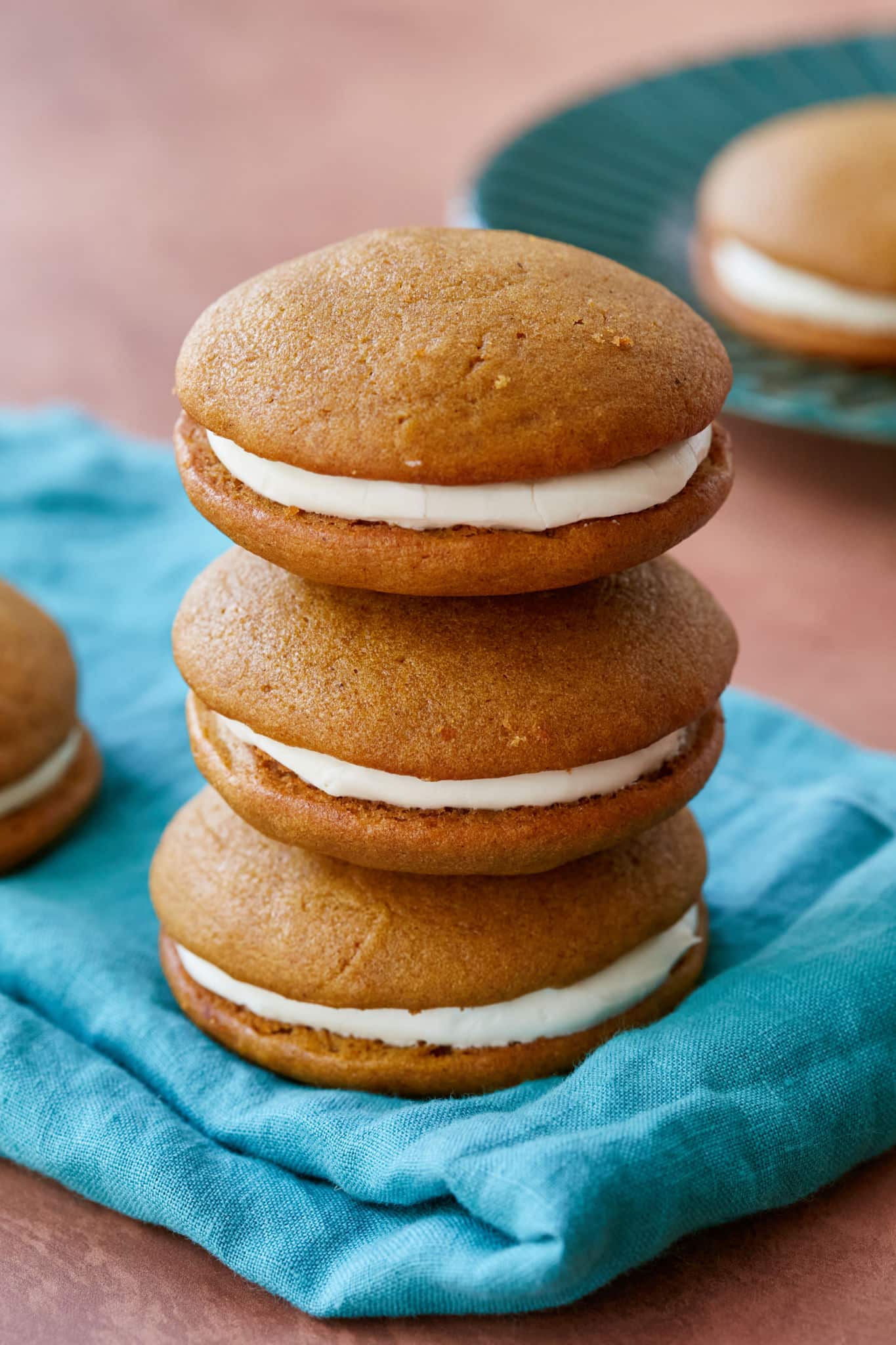A stack of whoopie pies filled with cream on a cloth.