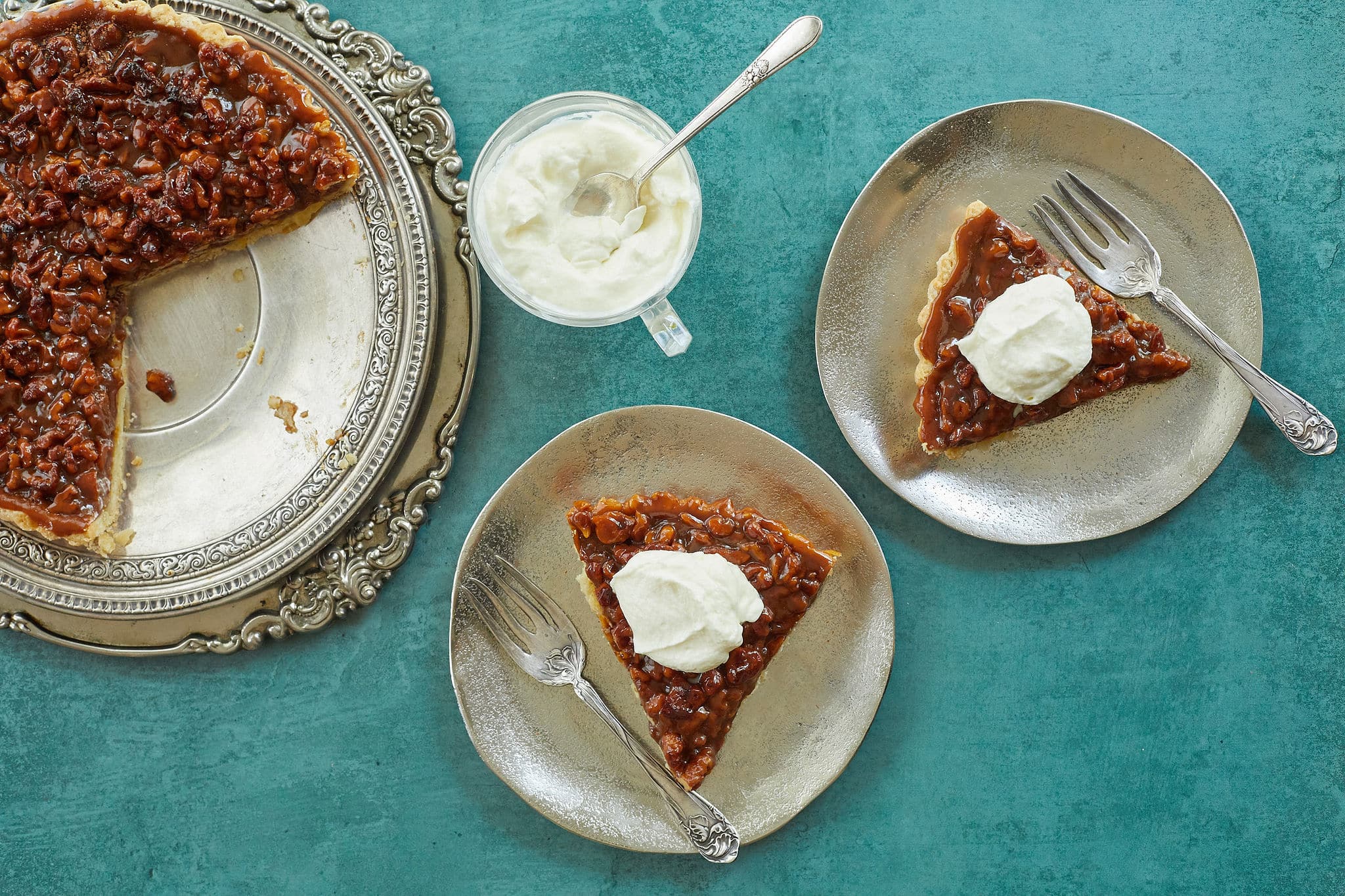 A walnut caramel tart sliced out and served.