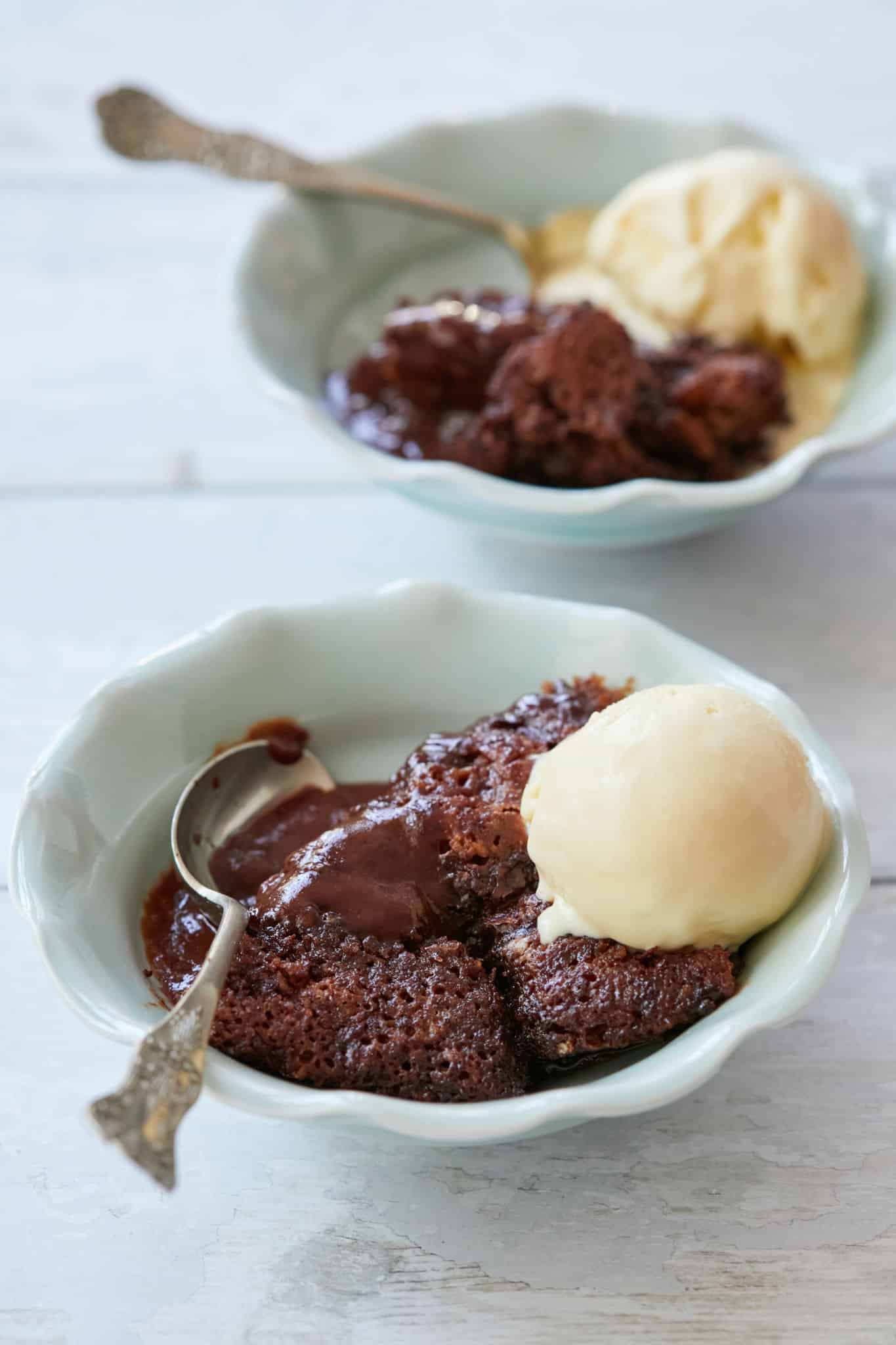 Two bowls of chocolate cobbler served with ice cream.