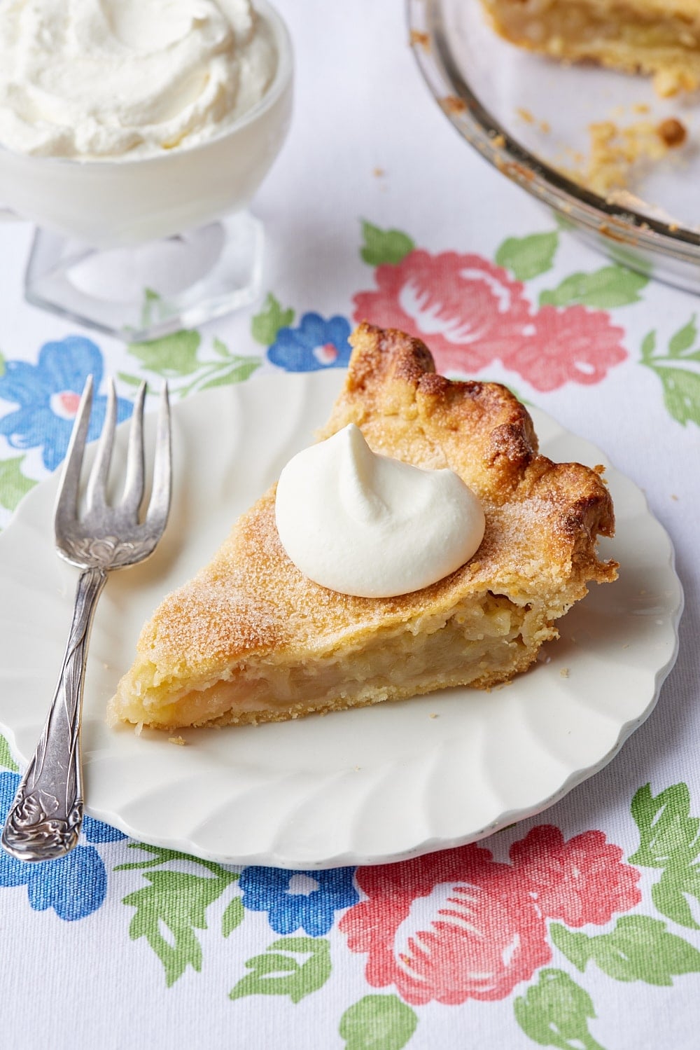 Classic Irish Apple Tart10 A slice of Classic Irish Apple tart is served on a dessert plate with a dollop of softly whipped cream.