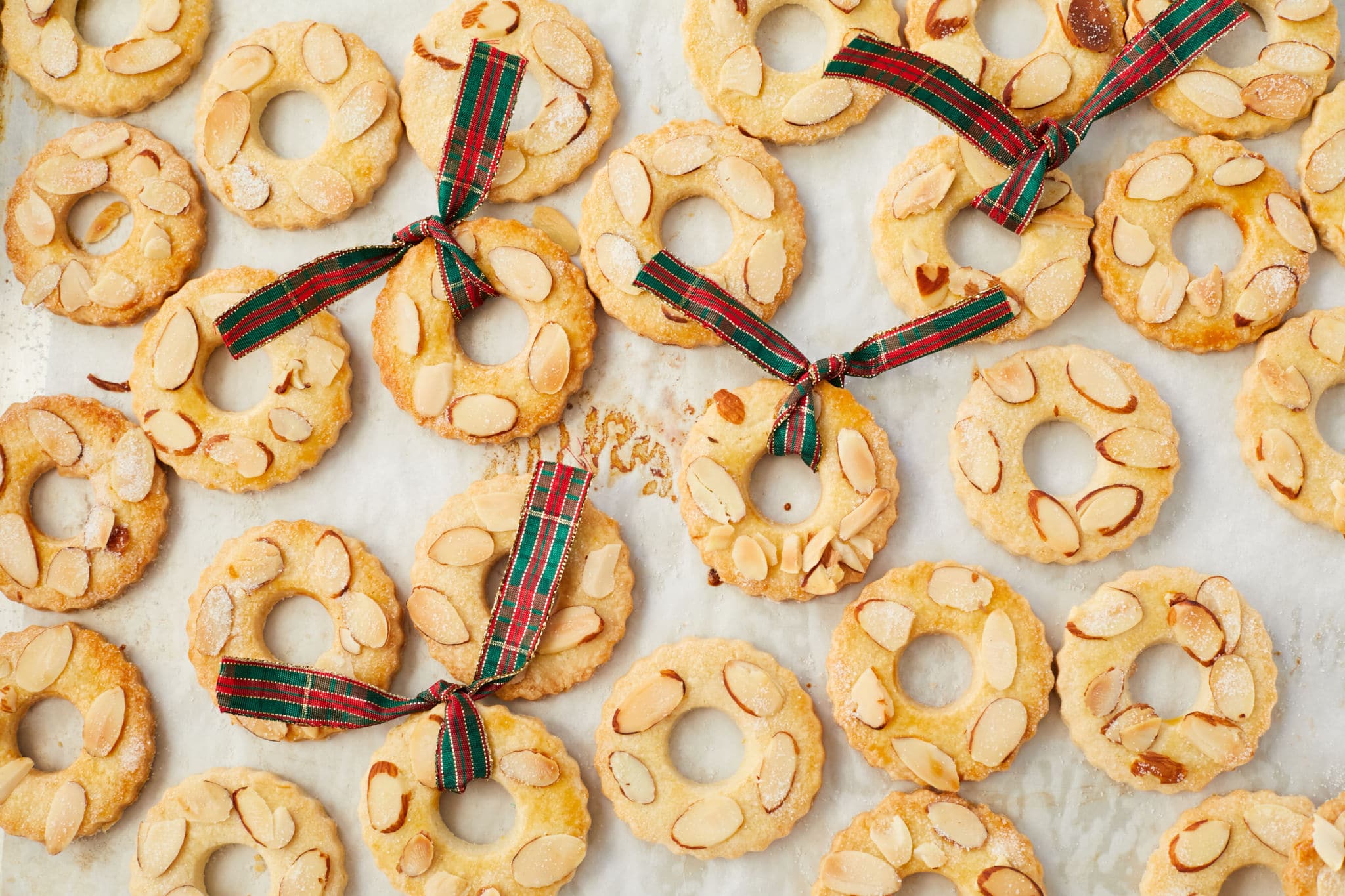 Kerstkransjes cookies spread out on a baking sheet.