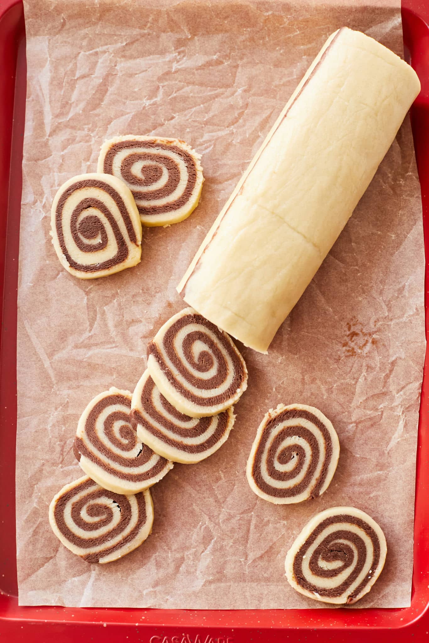 A log of pinwheel cookies being sliced.