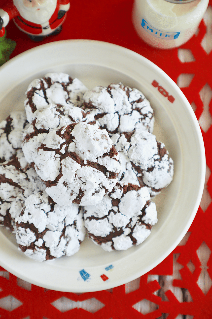 Chocolate Crinkle Cookies on a plate, covered in powdered sugar.