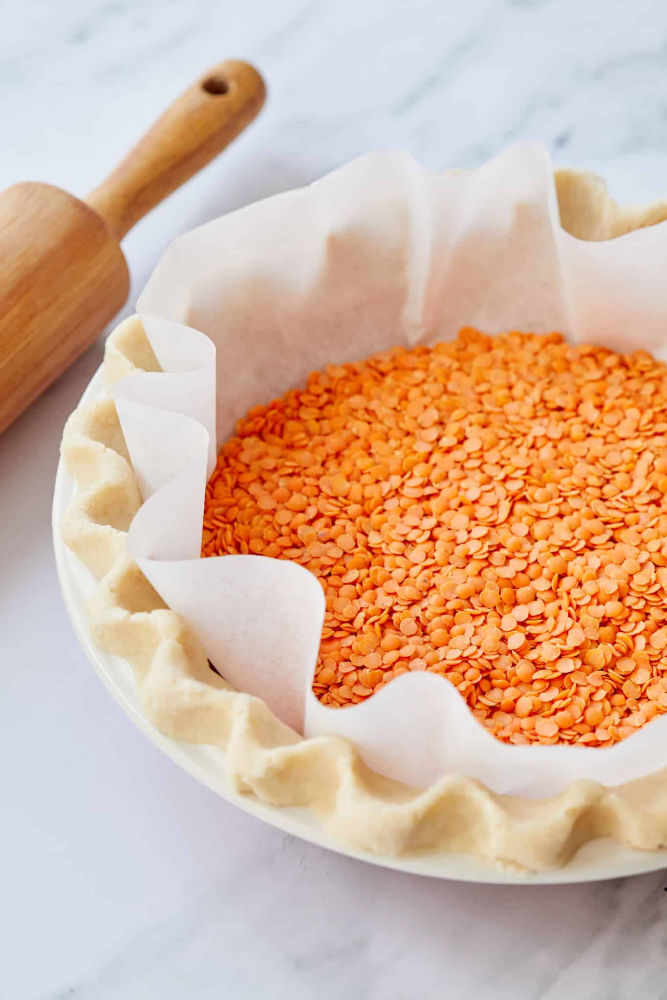 A pie crust filled with lentils for par-baking, or blind-baking.