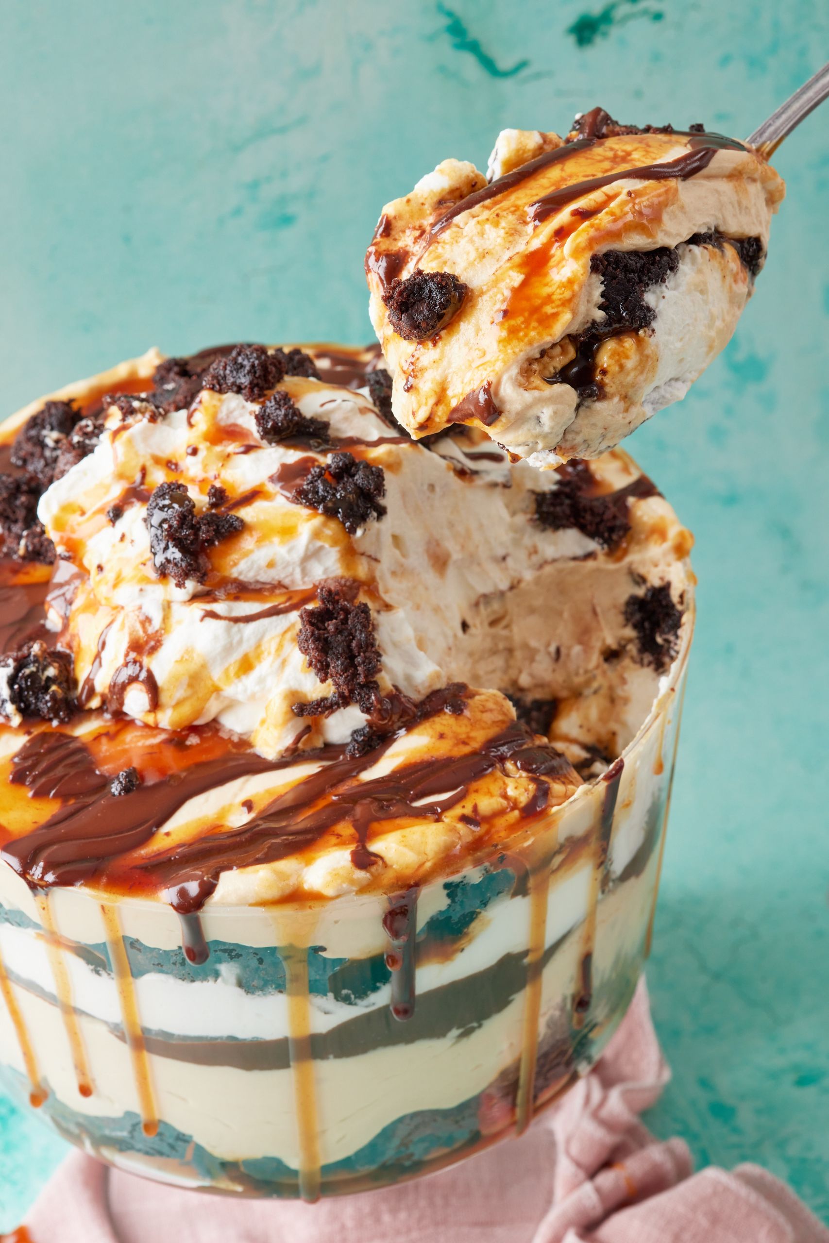 A spoonful of Chocolate Brownie Trifle is being lifted up, showing it creamy consistency and layers of goodness. 