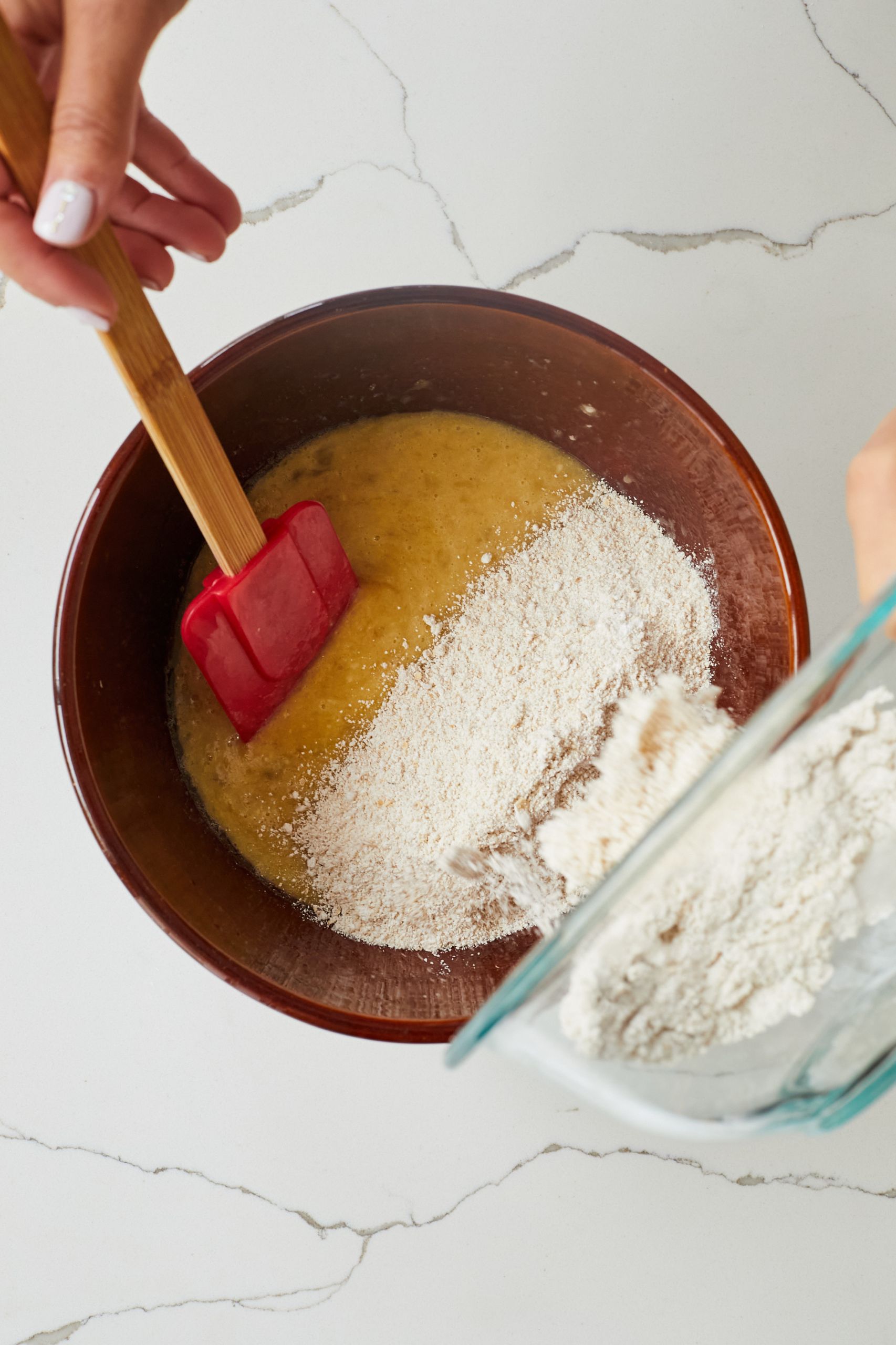 Step-by-step instructions on how to make applesauce muffins: mix dry ingredients and wet ingredients separately then combine. 