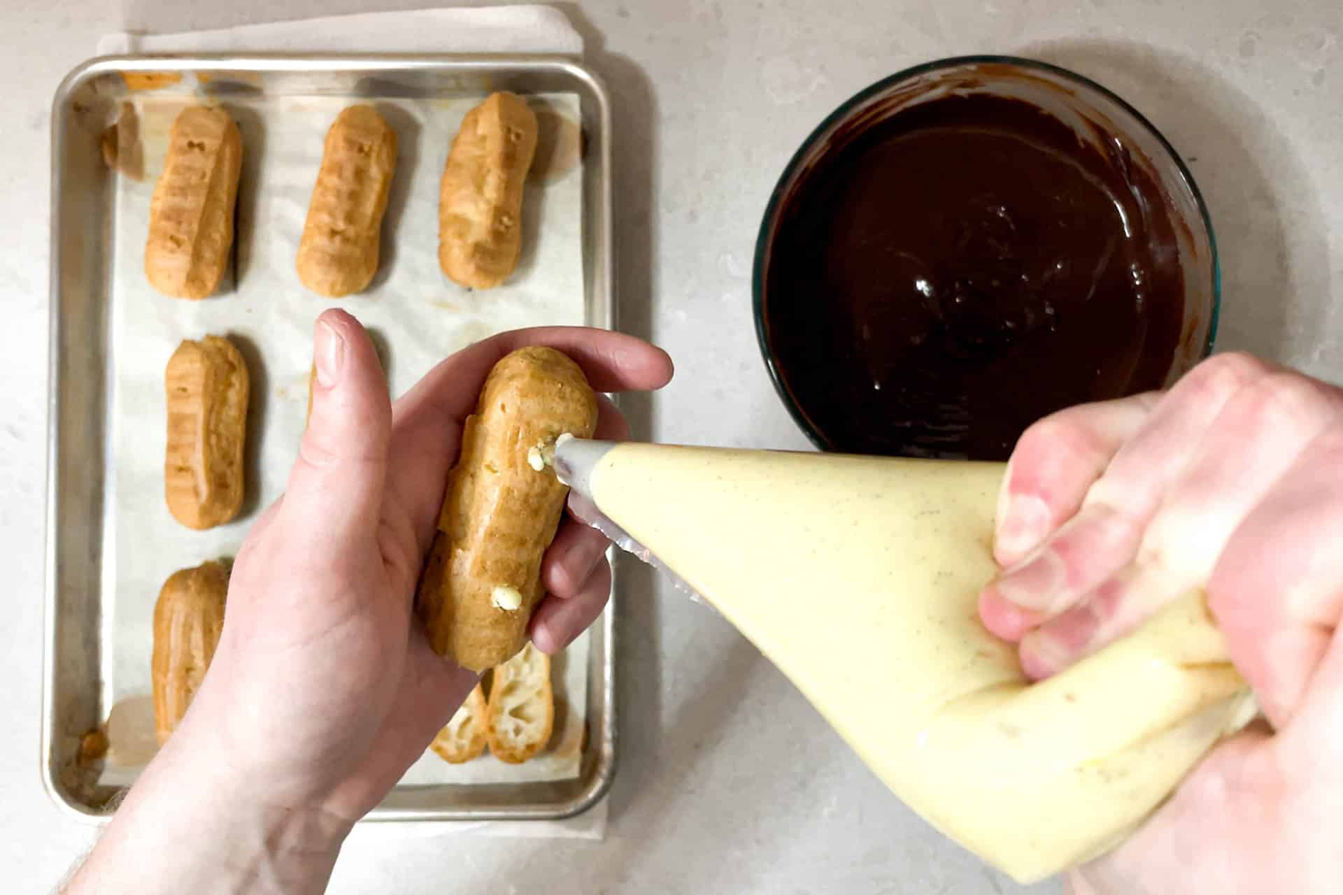 Filling the eclairs with pastry cream.