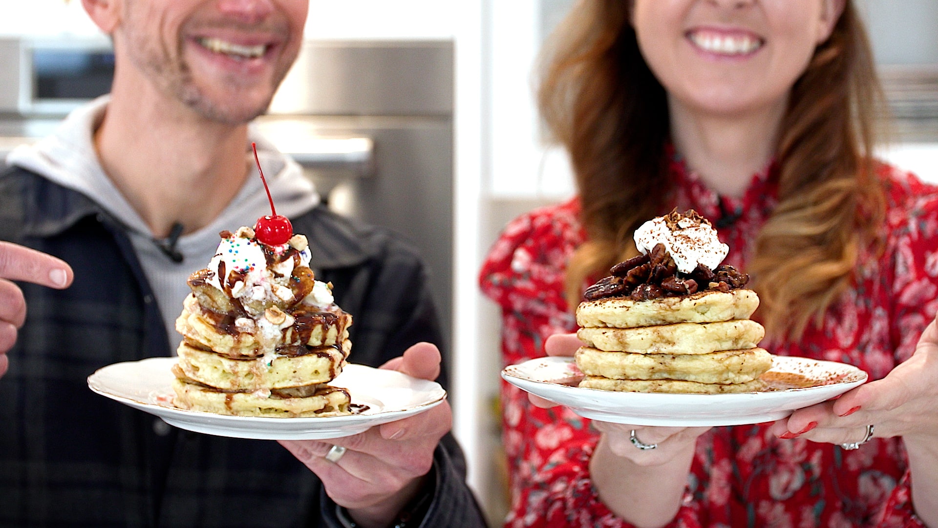 Two people holding up their finished pancakes.