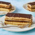 Three slices of This Classic Opera Cake are served, featuring layers of sponge cake, coffee syrup, French coffee buttercream, and chocolate butter glaze.