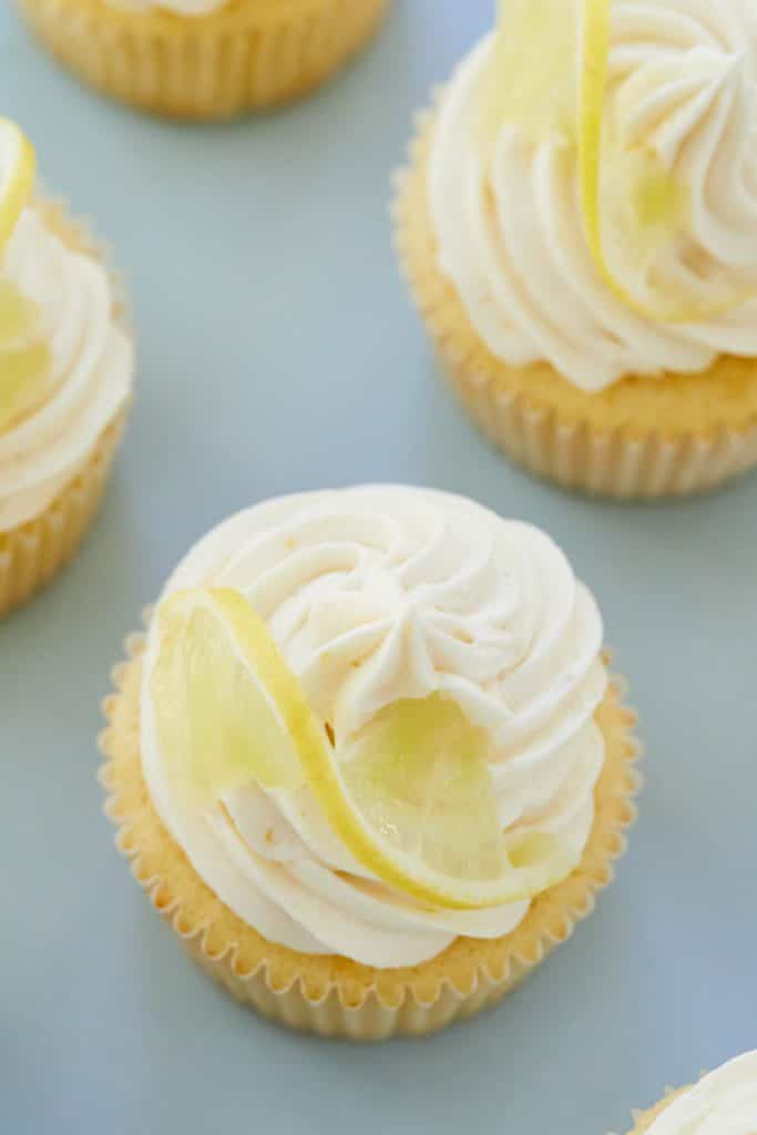 Top-down view of lemon cupcakes, each topped with a lemon slice.