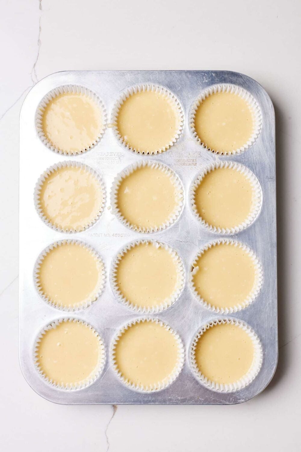 Pour cinnamon roll muffins batter in the muffin tin.