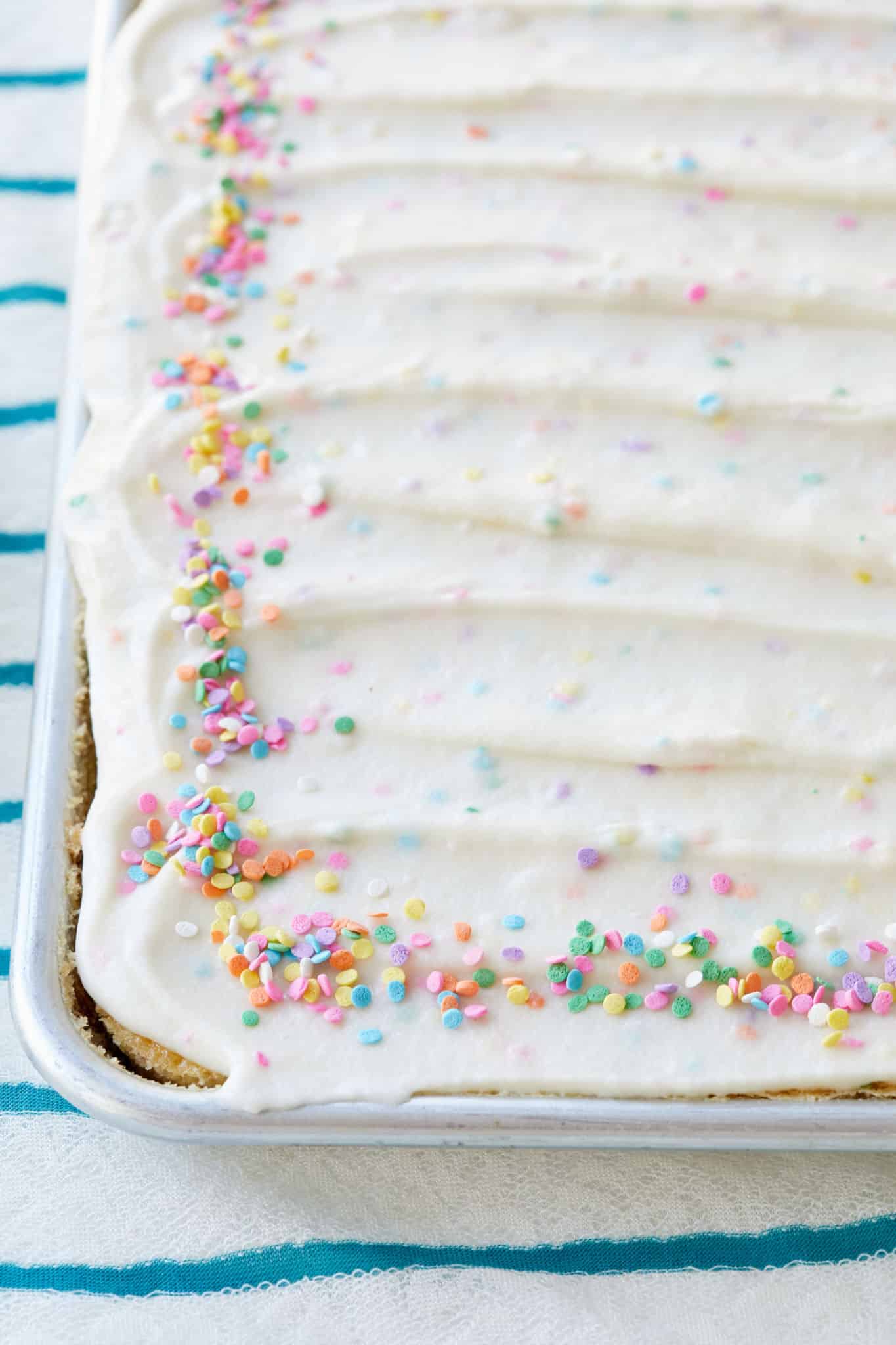 A cake topped with funfetti frosting.