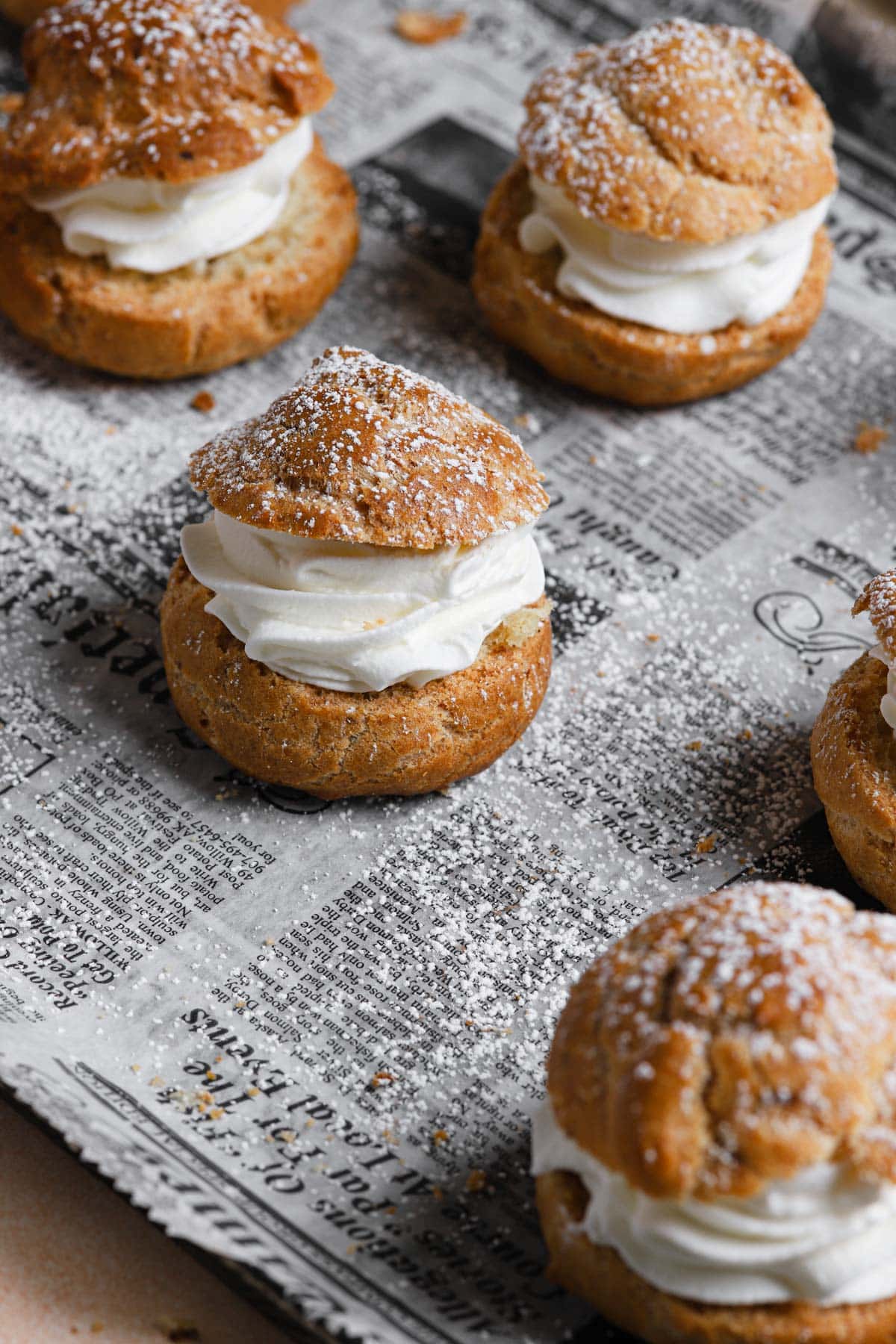 Cream puffs filled with cream and dusted with powdered sugar.