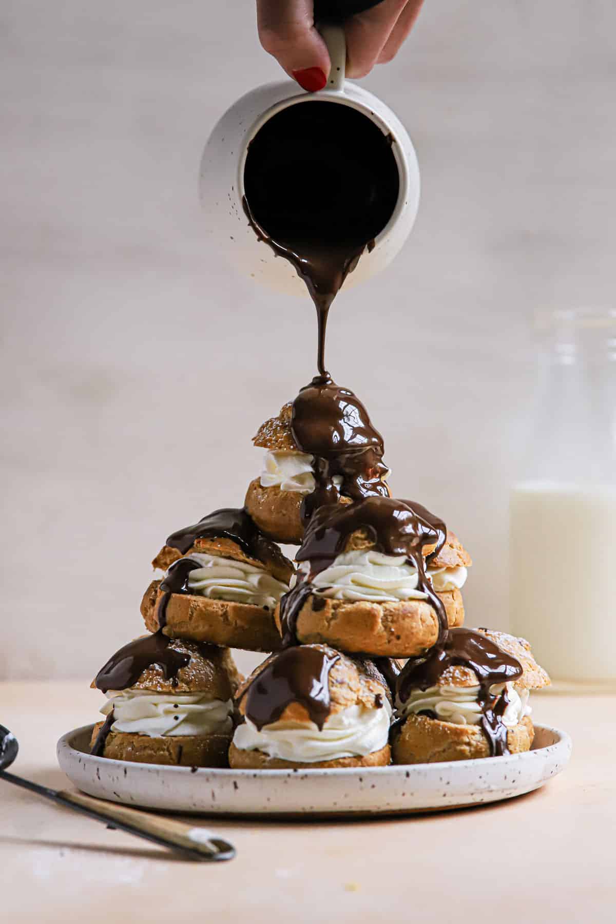 Cream Puffs being drizzled with chocolate.