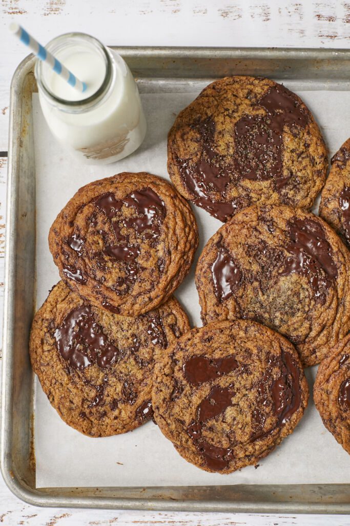 Best-Ever Chocolate Chip Cookies are baked golden brown with crinkled top and pools of chocolate. served with milk.