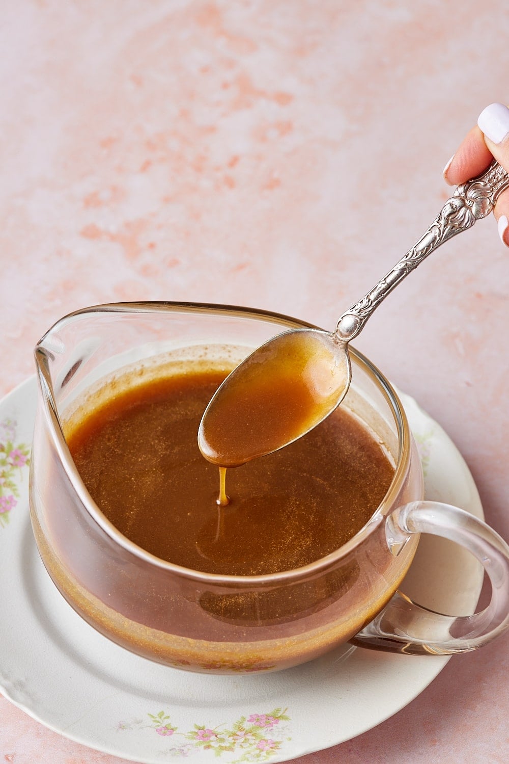 A spoonful of microwave caramel sauce dipping into the jug. 