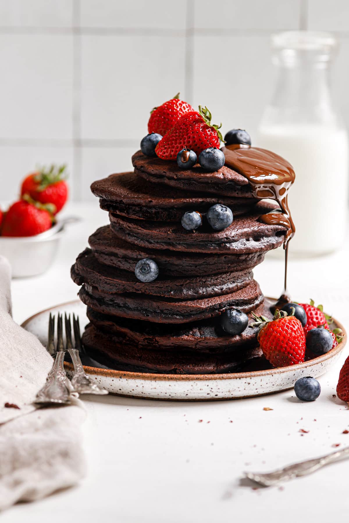 Chocolate Pancakes topped with berries and chocolate.