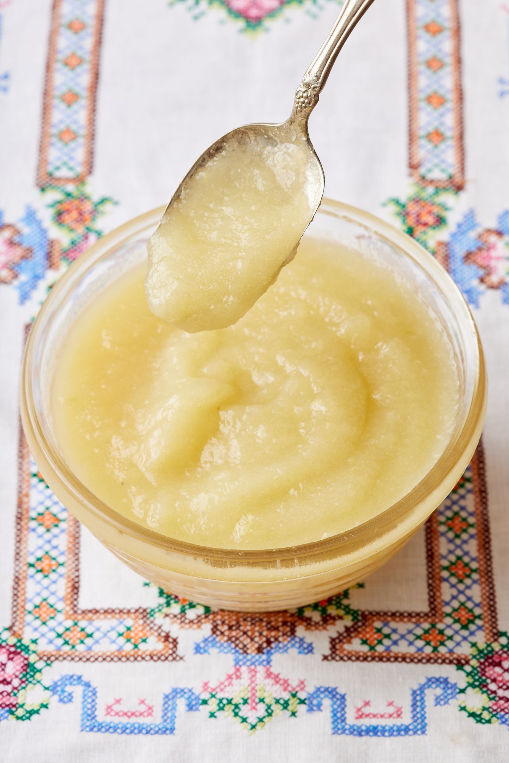 A spoonful of applesauce over the bowl. 