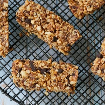 Bars of homemade Peanut Butter and Chocolate Chip Clif Bars are displayed on a black wire rack. The homemade energy bars are made with chocolate chips, oats, peanut butter, flaxseed, and more.