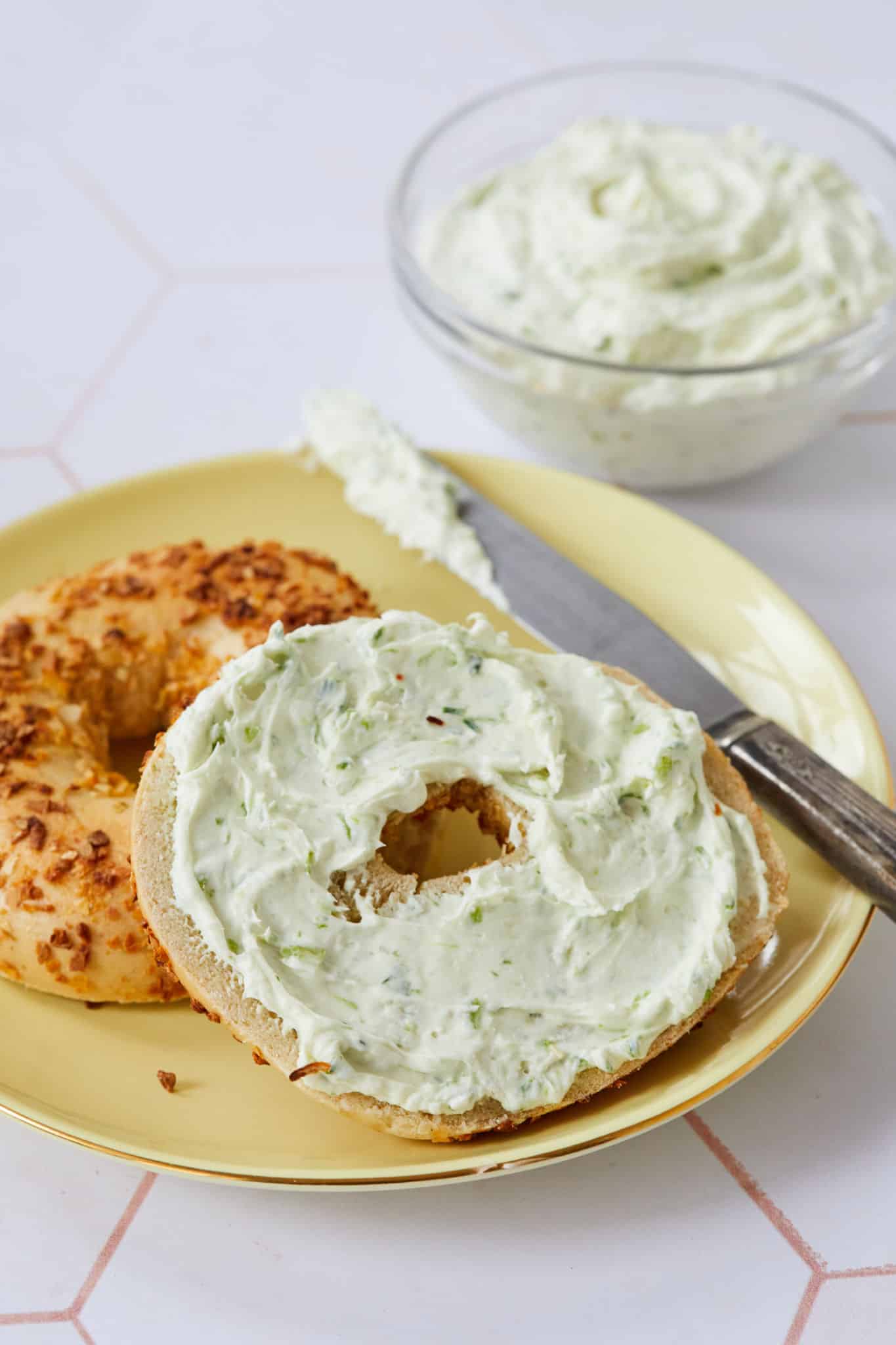 A close-up photo of the flavored cream cheese on the bagel. You can see the green of the chives.